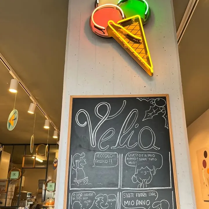Insegna al neon con il cono gelato e la lavagna Velia all'ingresso
