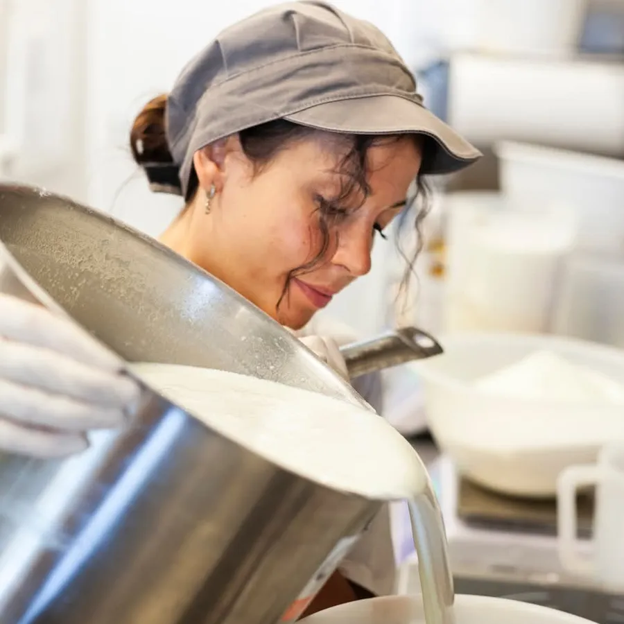 Gelatiera Velia in divisa e berretto mentre prepara il gelato in laboratorio